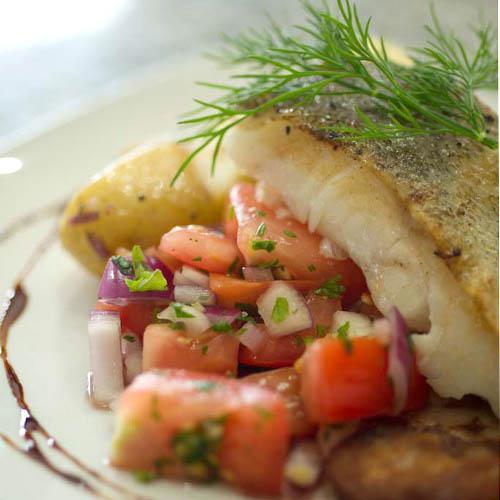 A plate of pan fried cod with potatoes and vegetables