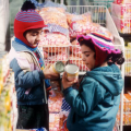 Two small children look at food in a supermarket