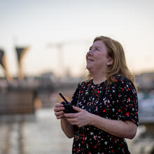Woman holding a walkie talkie looking up at the sky