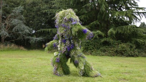 Photo of Grass Man - a living costume made of grass - posing in a park.