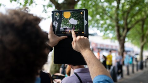 A person holds up a tablet to capture the scene before them.