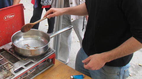 David Lisser cooking insects in his Future food café at Allenheads Village show, 2011