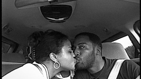 Woman and man kissing in a car