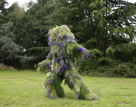 Image of a person wearing a suit made from living flora and fauna
