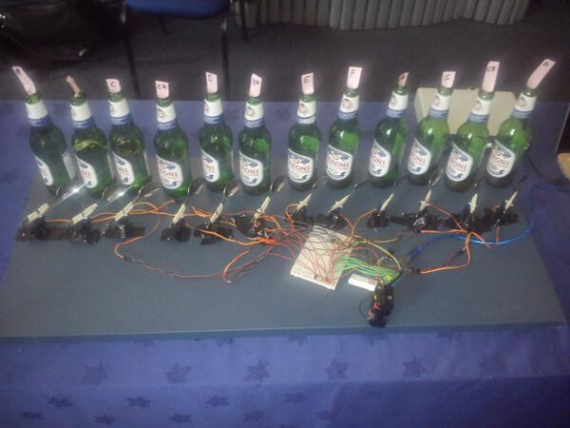 A row of bottles hooked up to a robotic musical system