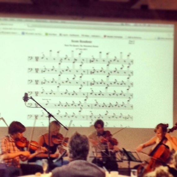 a group of musicians playing in front of a projected score