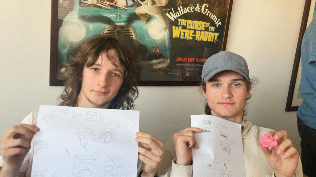 Two students showing their designs and model