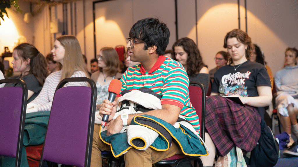 One attendee holding his jumper and microphone