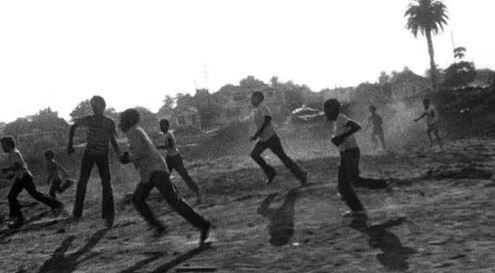 Black-and-white still from Killer of Sheep, a group of kids running on the sand.