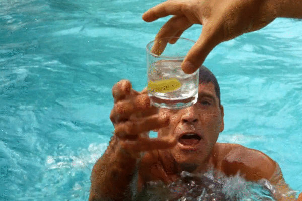 A man reaching out of pool for a drink