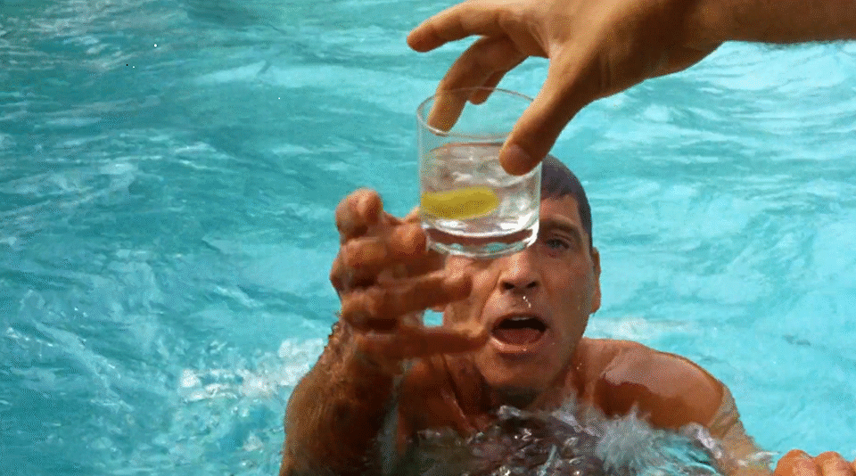 A man reaching out of pool for a drink