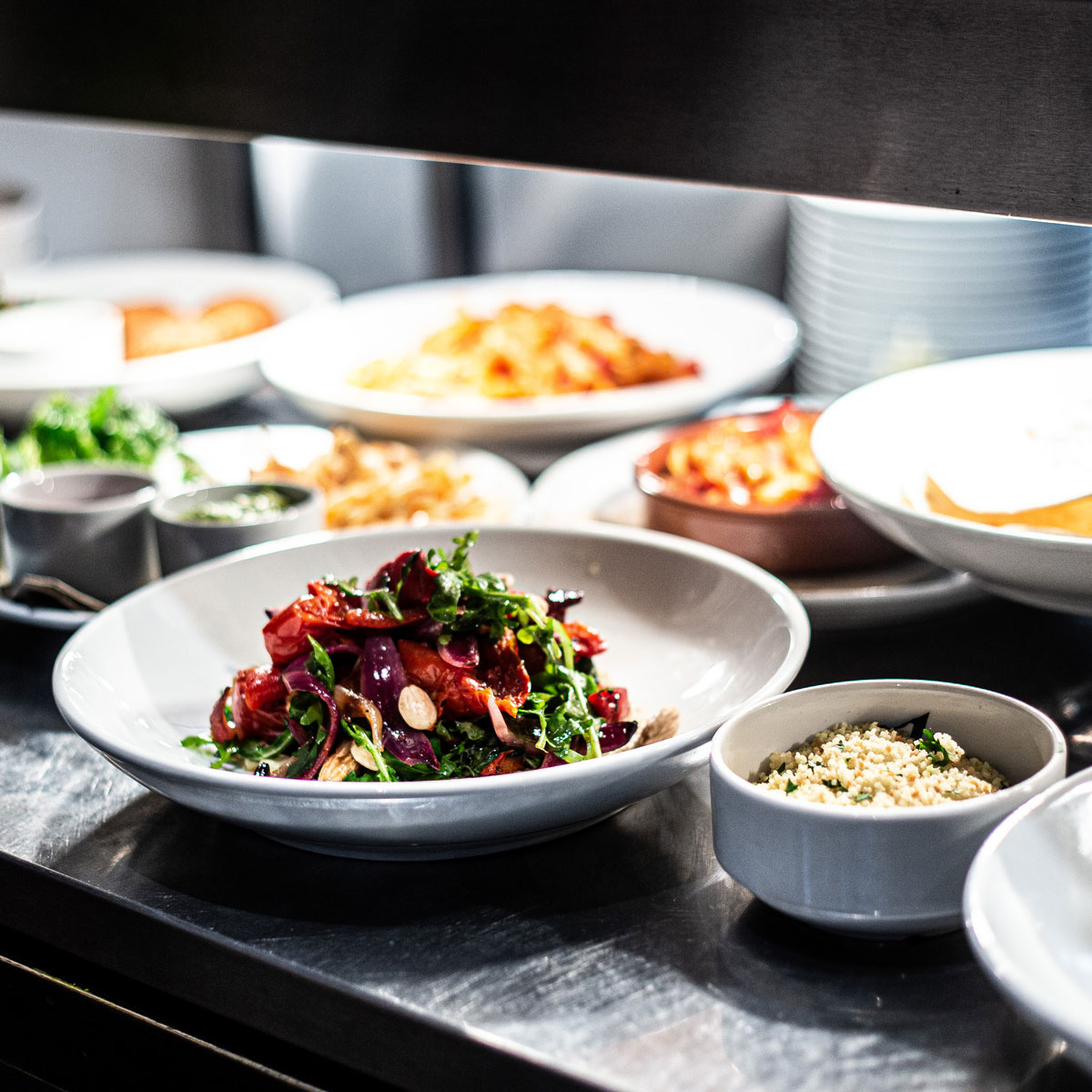 Photo of bowls of food in a kitchen, ready to be taken customers