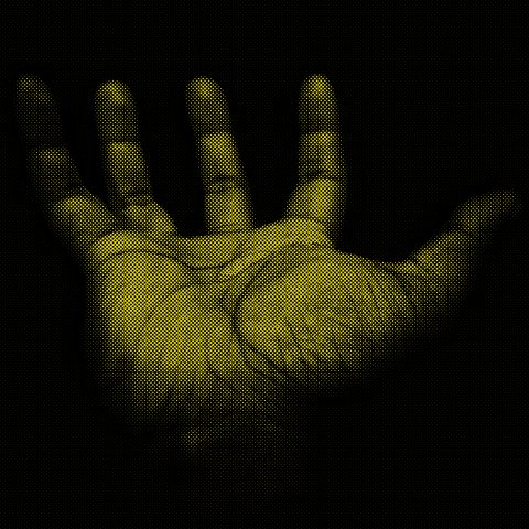 An outstretched palm under a yellow and black filter.