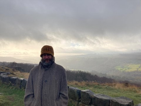 Image of Geraint Edwards in a mustard coloured hat with a grey coat on.