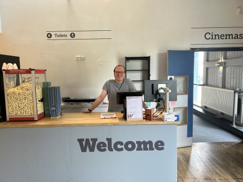 Photo of someone standing at the Welcome Desk.