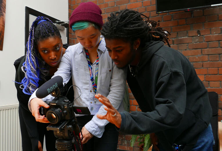 Three young people looking at a camera