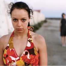 A photo of actress Samantha Morton in a coulrful top standing staring at the camera