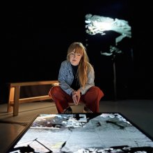 Amy Rose, Undershed Curator is peering down at a screen showing FRAMERATE: Pulse of the Earth