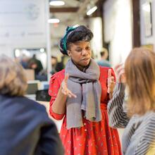 Photo of a woman standing and chatting to two other people