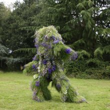 Photo of Grass Man - a living costume made of grass - posing in a park.