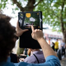 A person holds up a tablet to capture the scene before them.