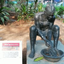 Statue of a woman washing clothes in a bowl