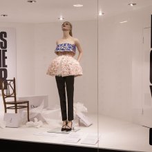 Photo of a fashion model in a shop window advertising Dress Of The Year Collection