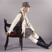 Photo of a fashion model sitting on a chair looking into the camera