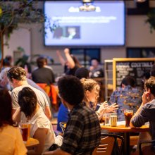 A full and lively Café & Bar with someone cheering in the background.
