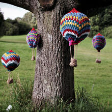 Mini wool balloons hanging from a tree