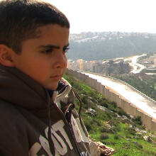 A boy looks over the wall