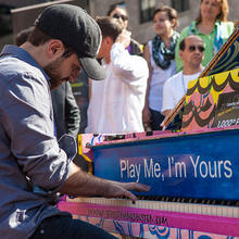 Man playing a piano outside