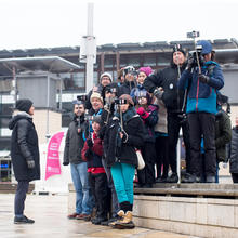 Group of people holding phones up with selfie sticks