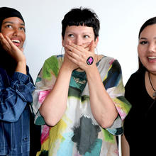 Three women with one covering her mouth with her hands