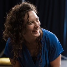 Photograph of smiling woman wearing a blue top.