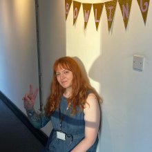 A still of Harriet Taylor, sitting in Watershed's Cinema Corridor.