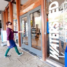 A woman walking into the front entrance to Watershed