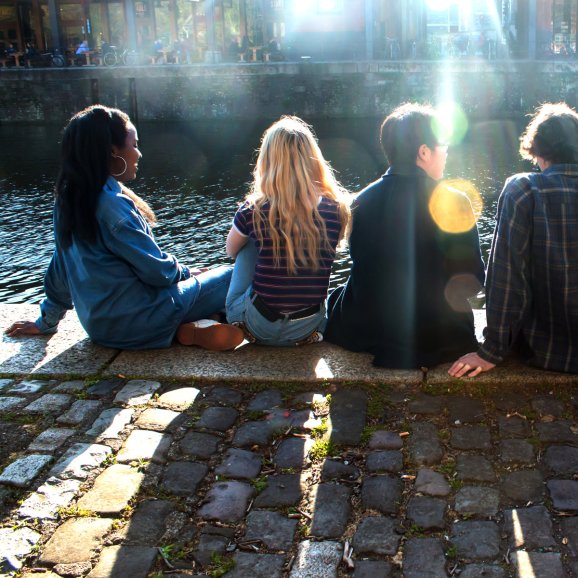 A photo of the backs of a group of 4 young people overlooking Watershed