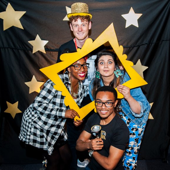 Photo of four young people, dressed up and celebrating
