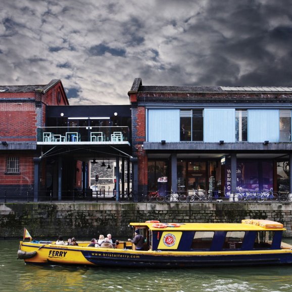 Photo of the exterior of Watershed with a ferry going past