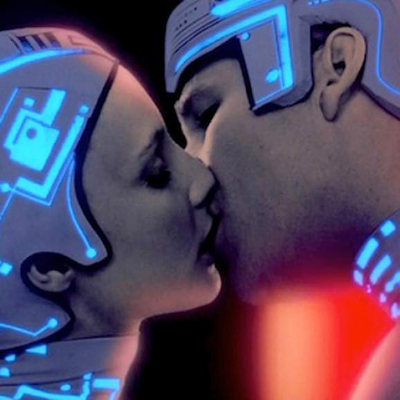 Scene from Ton - a couple dressed in neon headgear kissing.