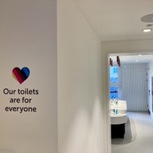 Entrance to the toilets with a mulit coloured heart - sinks and a window in the background