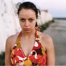 A photo of actress Samantha Morton in a coulrful top standing staring at the camera