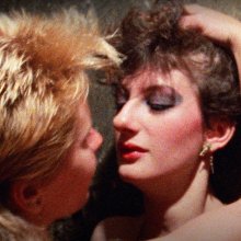 A close up colour photo of two people about to passionately kiss