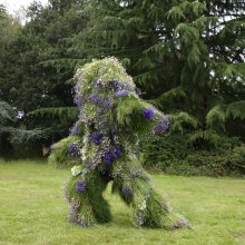Photo of Grass Man - a living costume made of grass - posing in a park.