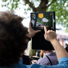 A person holds up a tablet to capture the scene before them.