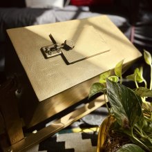 A gold painted rectangular box with a little door.