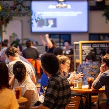 A full and lively Café & Bar with someone cheering in the background.