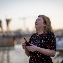 Woman holding a walkie talkie looking up at the sky