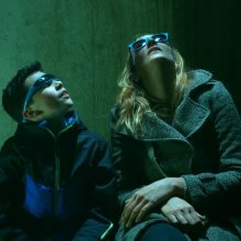 Two people wearing sunglasses looking up
